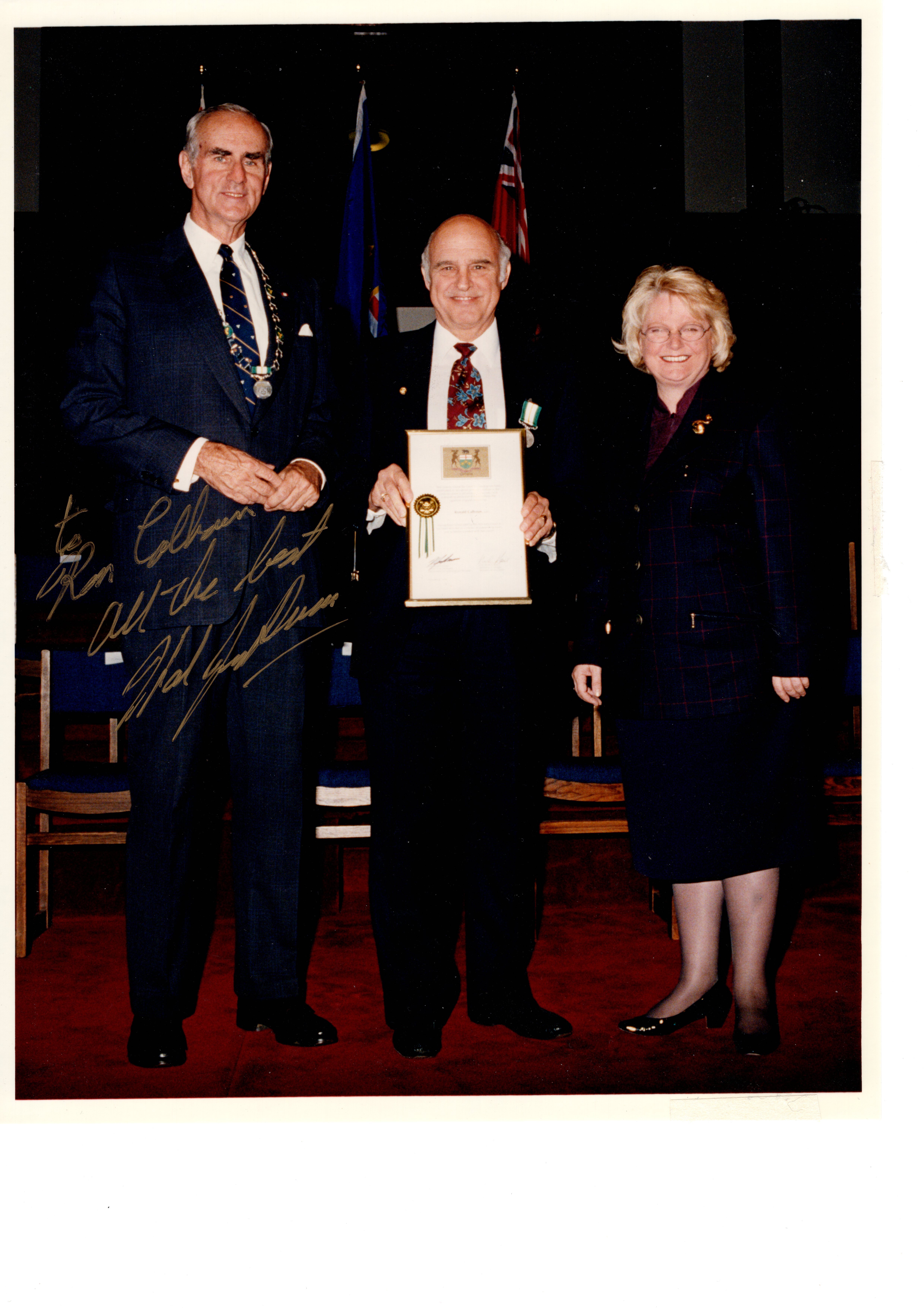 Ron Calhoun holding an award certificate at a presentation